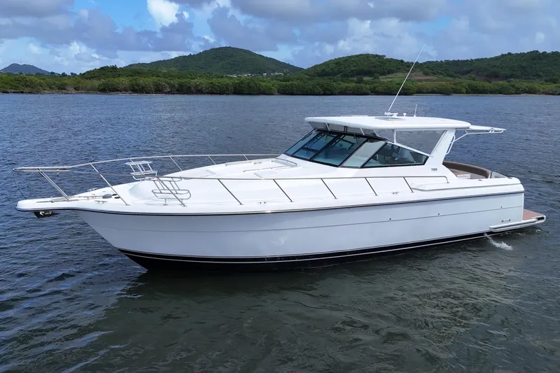  Yacht Photos Pics 2003 Tiara Yachts 4000 Express cruising on a scenic lake with lush green hills.