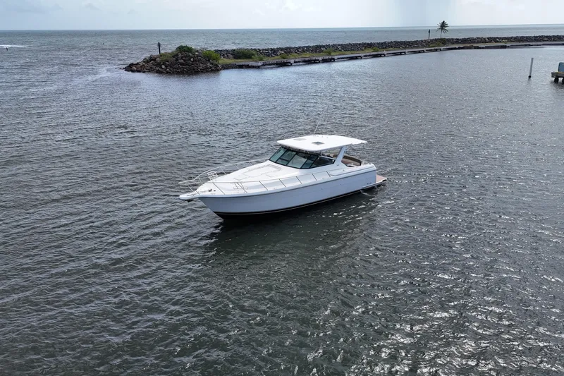  Yacht Photos Pics 2003 Tiara Yachts 4000 Express cruising in open water near rocky shoreline.