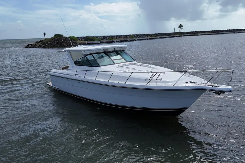  Yacht Photos Pics 2003 Tiara Yachts 4000 Express cruising on a calm sea under a cloudy sky.