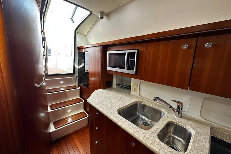  Yacht Photos Pics Luxurious 2003 Tiara Yachts 4000 Express kitchen with wooden cabinetry and modern appliances.