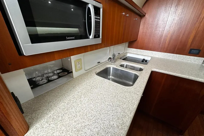  Yacht Photos Pics 2003 Tiara Yachts 4000 Express kitchen with microwave, dual sinks, and wooden cabinetry.