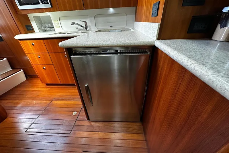  Yacht Photos Pics 2003 Tiara Yachts 4000 Express kitchen with stainless steel fridge and wooden cabinetry.
