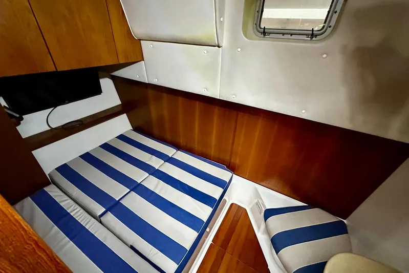  Yacht Photos Pics 2003 Tiara Yachts 4000 Express cabin with striped bedding and wooden interior.