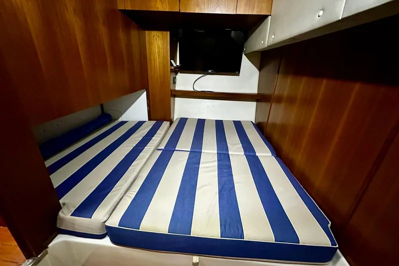  Yacht Photos Pics 2003 Tiara Yachts 4000 Express cabin with striped bedding and wooden interior.