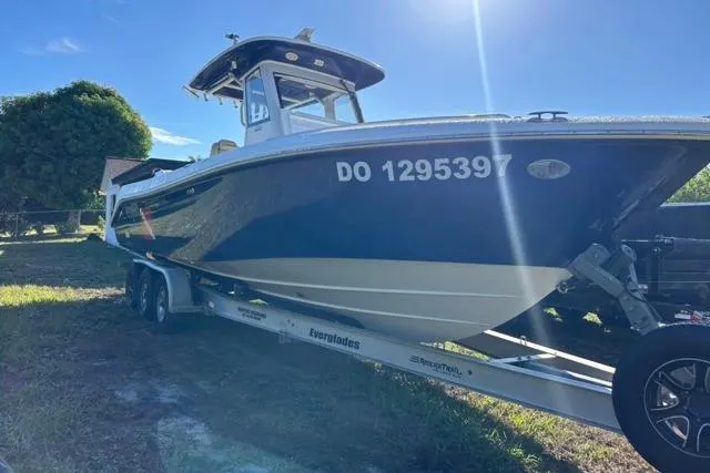  Yacht Photos Pics 2019 Everglades 290 Center Console boat on trailer, parked outdoors under clear blue sky.