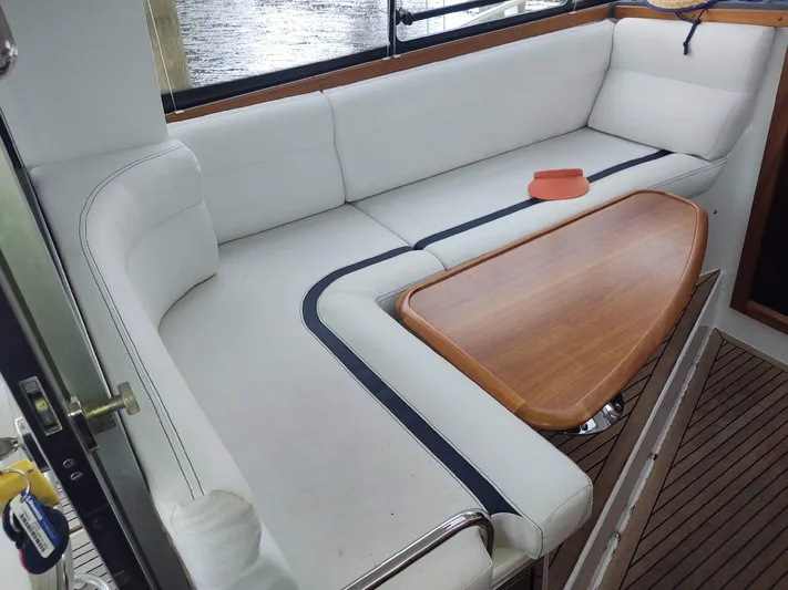 Ya Bawwt It Yacht Photos Pics 2017 Nimbus 34 Nova boat interior with white seating and wooden table.