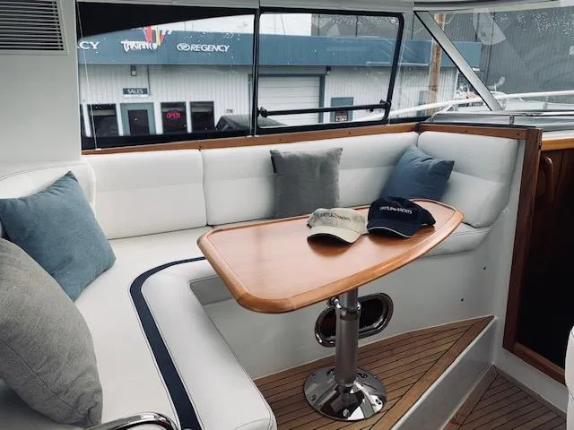 Ya Bawwt It Yacht Photos Pics Interior of 2017 Nimbus 34 Nova boat with cushioned seating and wooden table.