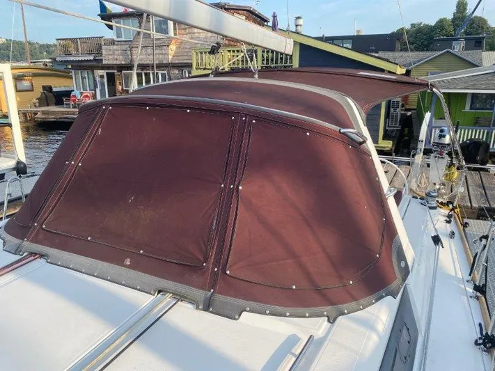 Hey Jude III Yacht Photos Pics 2015 Beneteau Oceanis 45 sailboat with maroon canopy docked near waterfront homes.