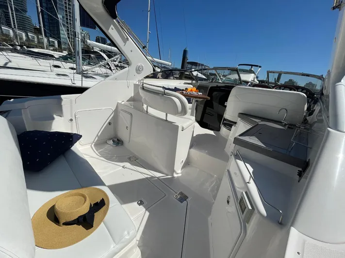 Samari Yacht Photos Pics 2007 Regal 3760 Sportyacht interior with seating, table, and hat on a sunny day.