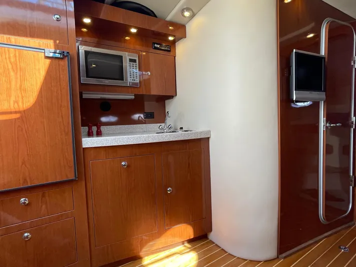 Samari Yacht Photos Pics 2007 Regal 3760 Sportyacht interior with wooden cabinetry, microwave, and TV.