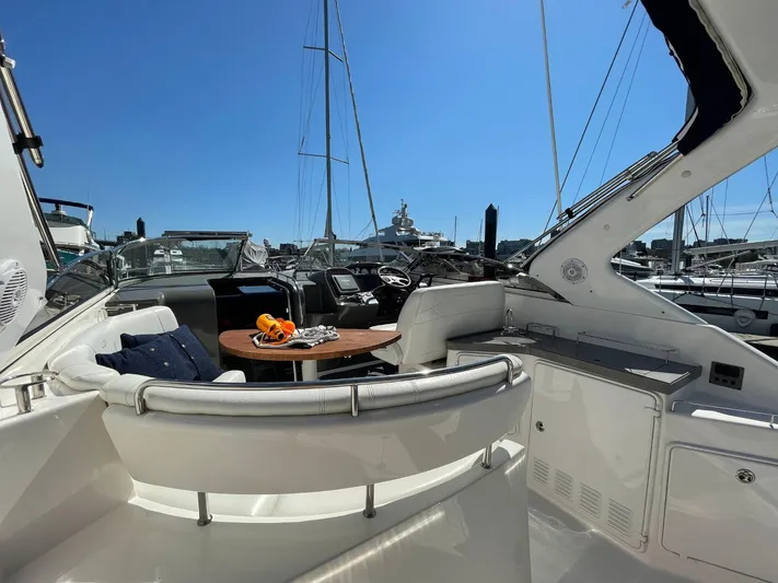 Samari Yacht Photos Pics 2007 Regal 3760 Sportyacht interior with seating and table, docked at marina under clear blue sky.