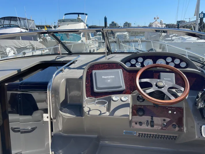 Samari Yacht Photos Pics 2007 Regal 3760 Sportyacht helm with wooden steering wheel and navigation system at marina.