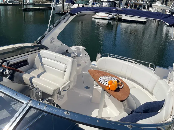 Samari Yacht Photos Pics 2007 Regal 3760 Sportyacht interior with white seating, wooden table, and marina view.