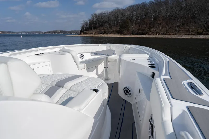  Yacht Photos Pics 2026 Fountain 43 SCX boat interior with luxurious seating and table on a calm lake.