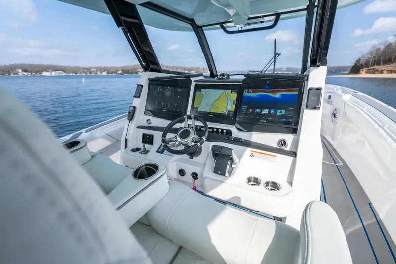  Yacht Photos Pics 2026 Fountain 43 SCX boat cockpit with advanced navigation displays on a serene lake.