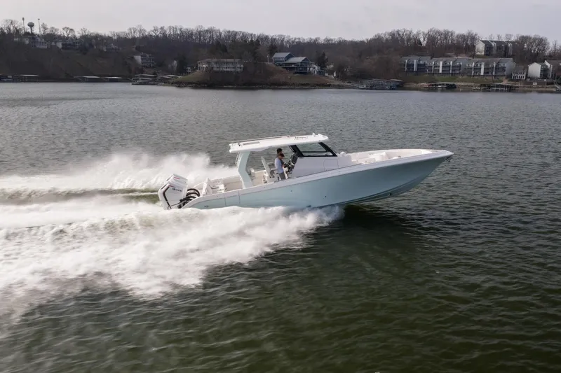  Yacht Photos Pics 2026 Fountain 43 SCX speedboat cruising on a lake with scenic shoreline.