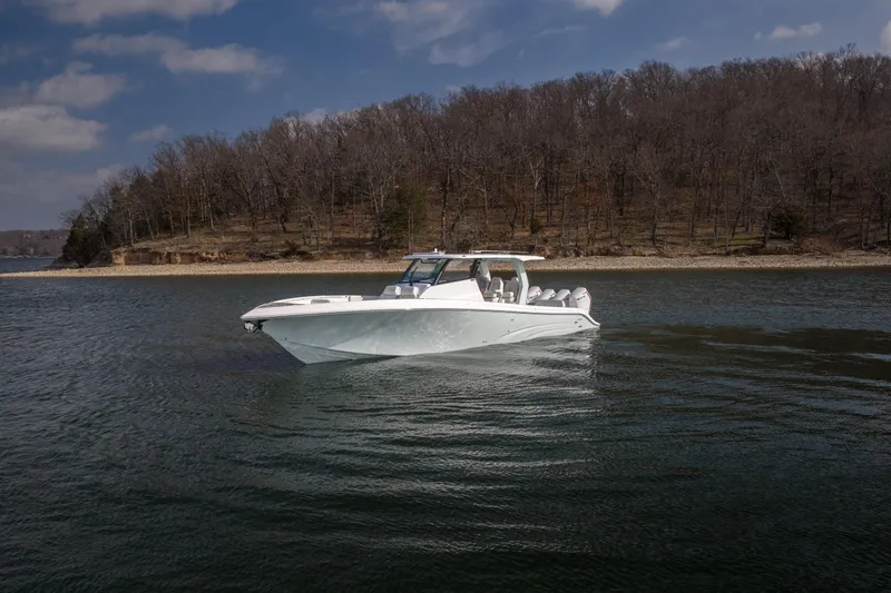  Yacht Photos Pics 2026 Fountain 43 SCX boat cruising on a calm lake with wooded shoreline.