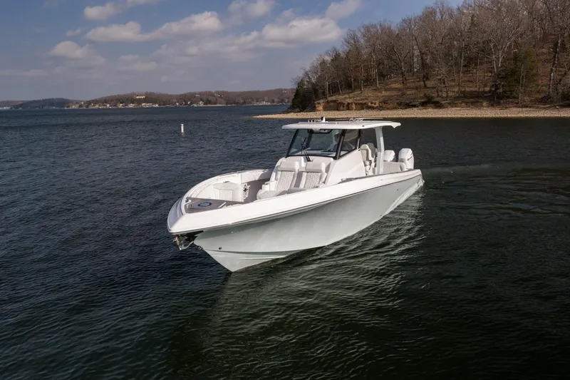  Yacht Photos Pics 2026 Fountain 43 SCX boat cruising on a serene lake under a partly cloudy sky.