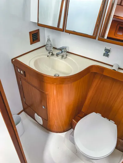 Violina Yacht Photos Pics Bathroom interior of a 1999 Hylas 54 yacht with wooden cabinetry and white fixtures.