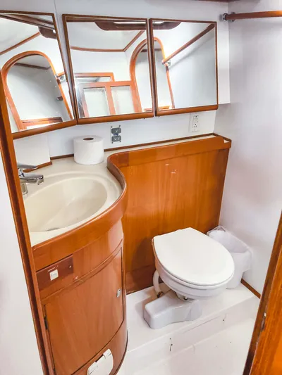 Violina Yacht Photos Pics 1999 Hylas 54 yacht bathroom with wooden cabinetry and white fixtures.