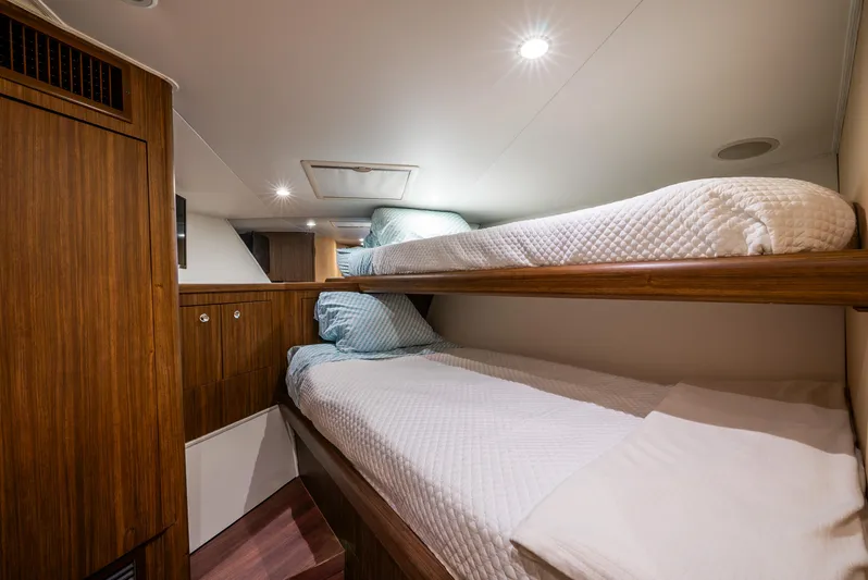 Knotty Girl Yacht Photos Pics Bunk beds in the 2005 Viking 52 Convertible yacht cabin, featuring wooden cabinetry and cozy bedding.