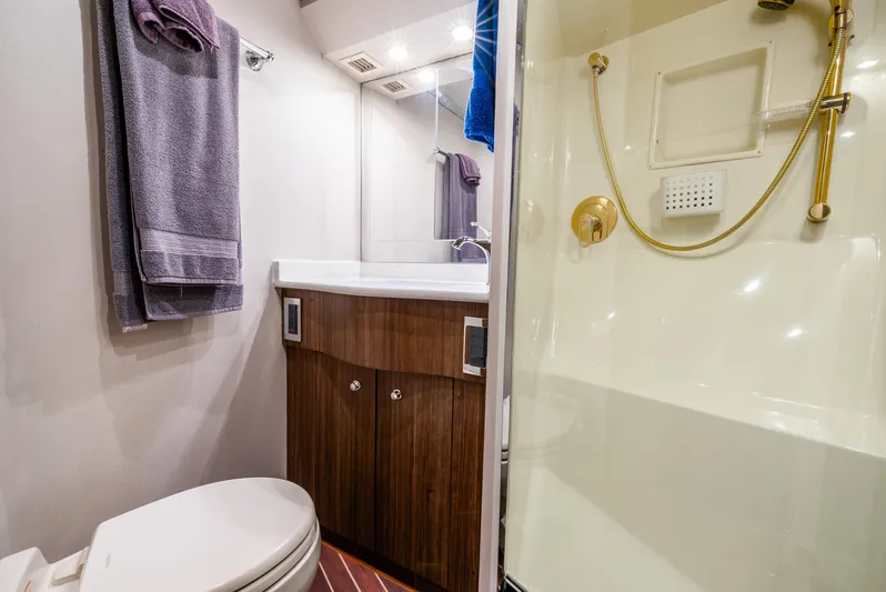 Knotty Girl Yacht Photos Pics 2005 Viking 52 Convertible yacht bathroom with shower, toilet, and vanity.
