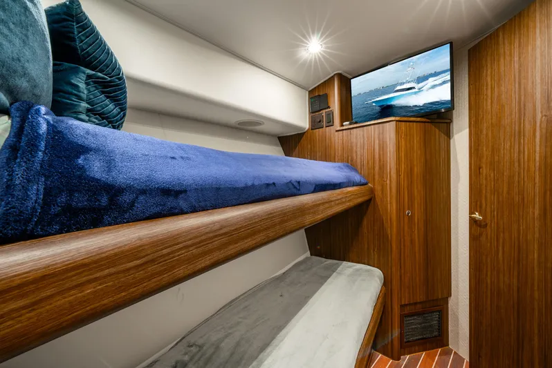 Knotty Girl Yacht Photos Pics Interior cabin of a 2005 Viking 52 Convertible yacht with bunk beds and TV.