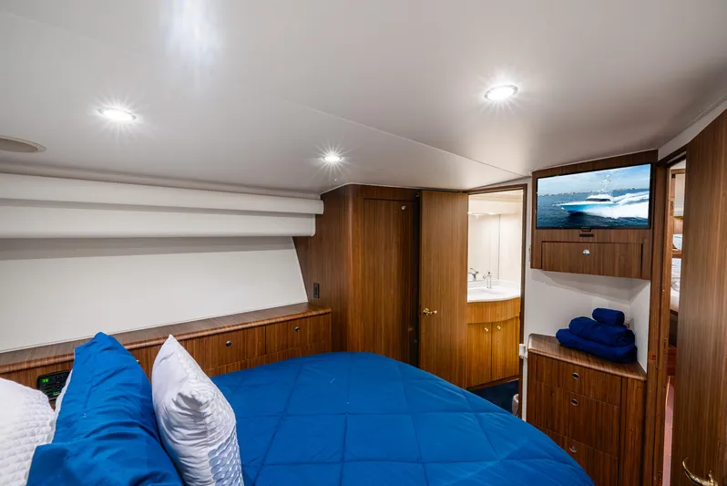 Knotty Girl Yacht Photos Pics Luxurious bedroom interior of 2005 Viking 52 Convertible yacht with blue bedding.