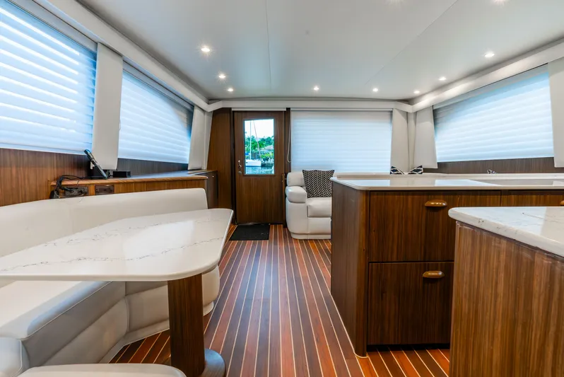 Knotty Girl Yacht Photos Pics Interior of 2005 Viking 52 Convertible yacht with modern wood finishes and white seating.