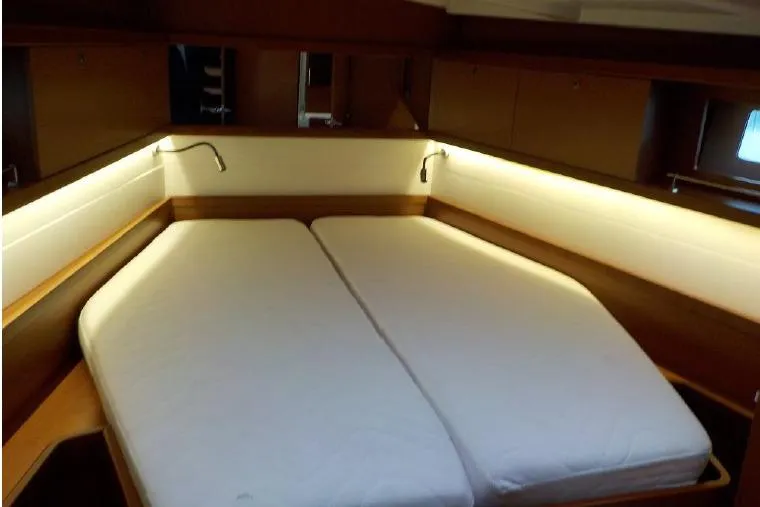  Yacht Photos Pics Cozy cabin interior of 2017 Beneteau Oceanis 45 yacht with double bed and ambient lighting.