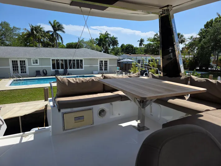 Neptune's Revenge Yacht Photos Pics 2017 Fountaine Pajot MY37 yacht with outdoor seating, table, and poolside view.