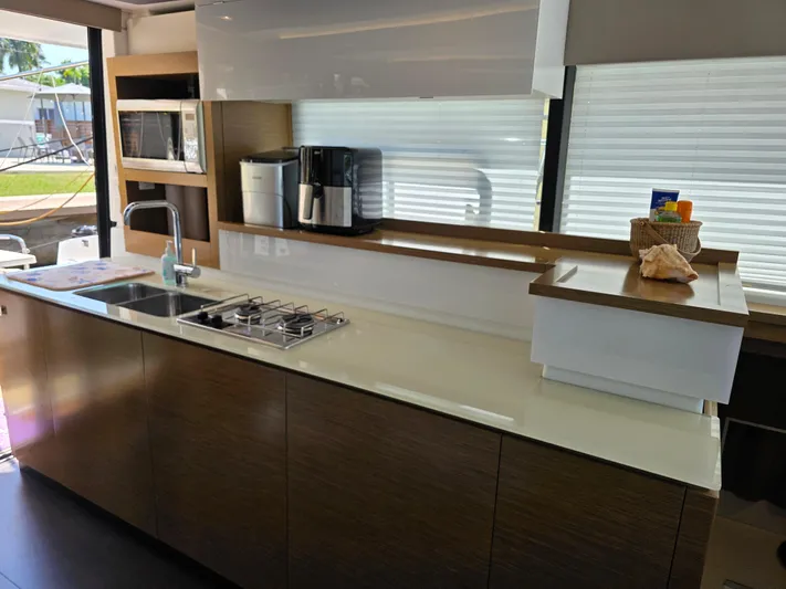 Neptune's Revenge Yacht Photos Pics Modern kitchen interior on 2017 Fountaine Pajot MY37 yacht with sleek countertops and appliances.