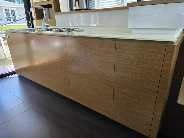 Neptune's Revenge Yacht Photos Pics Modern kitchen interior on 2017 Fountaine Pajot MY37 yacht, featuring sleek wooden cabinetry.