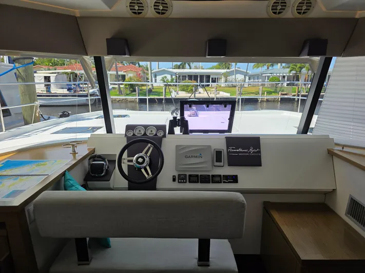 Neptune's Revenge Yacht Photos Pics Helm of 2017 Fountaine Pajot MY37 yacht with navigation equipment and waterfront view.