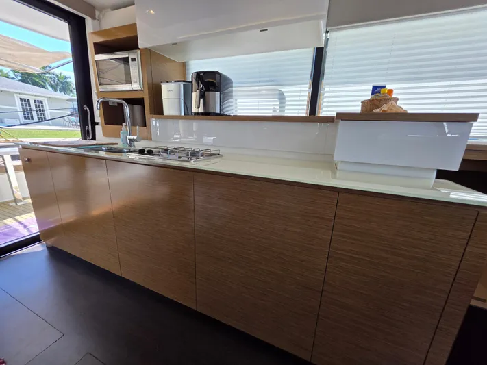 Neptune's Revenge Yacht Photos Pics Modern kitchen interior on 2017 Fountaine Pajot MY37 yacht, featuring sleek cabinetry and appliances.