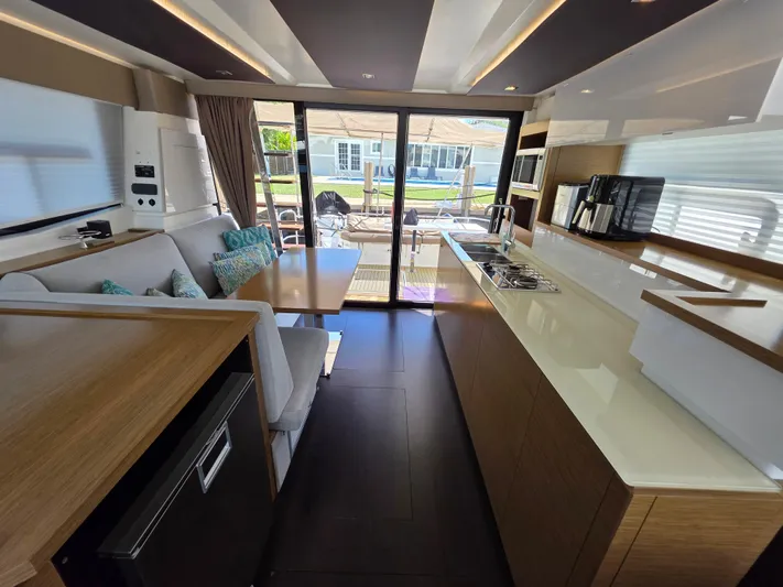 Neptune's Revenge Yacht Photos Pics Luxurious interior of 2017 Fountaine Pajot MY37 yacht with modern kitchen and seating area.