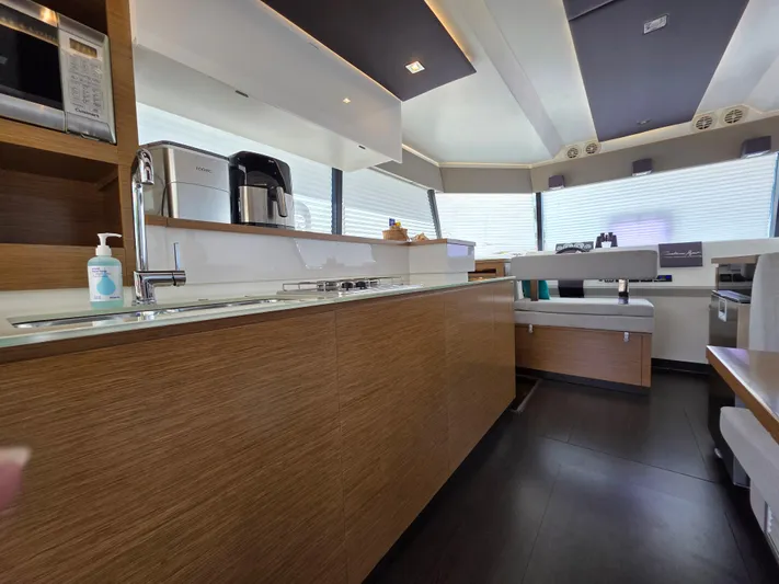 Neptune's Revenge Yacht Photos Pics Luxurious interior of 2017 Fountaine Pajot MY37 yacht with modern kitchen amenities.