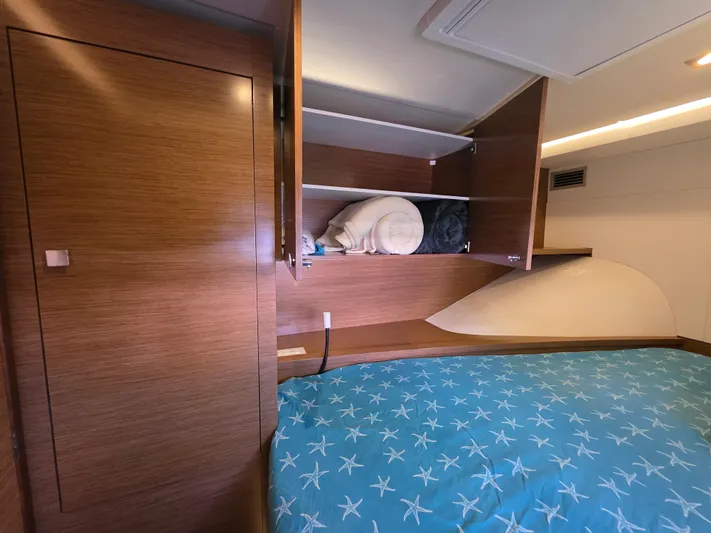 Neptune's Revenge Yacht Photos Pics 2017 Fountaine Pajot MY37 cabin with wooden shelves and starfish-patterned bedding.