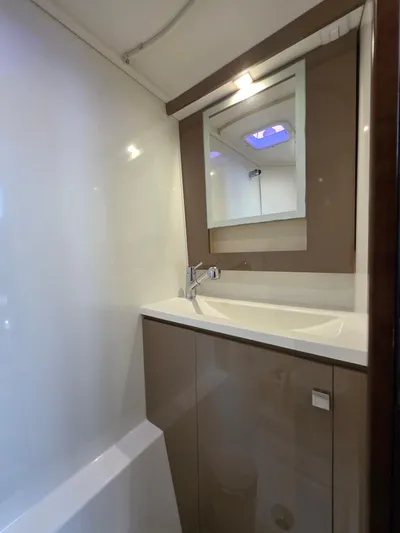 Neptune's Revenge Yacht Photos Pics Bathroom interior of 2017 Fountaine Pajot MY37 yacht, featuring modern sink and mirror.