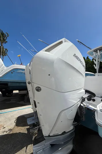  Yacht Photos Pics 2024 Crevalle 33 CSF boat with Mercury outboard motor, docked under clear blue sky.