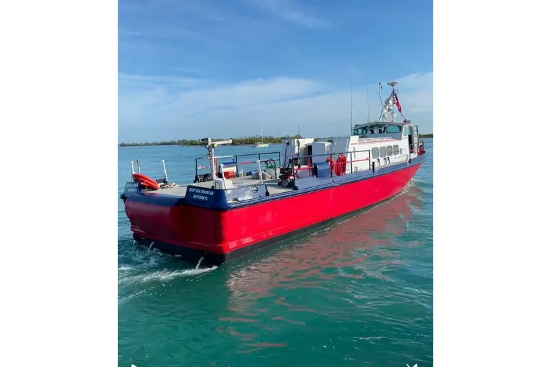 Deep Sea Traveler Yacht Photos Pics Red and blue 1964 custom commercial boat on calm water under clear sky.