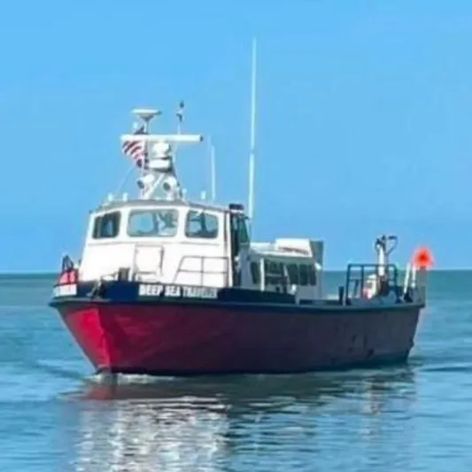 Deep Sea Traveler Yacht Photos Pics 1964 custom commercial boat "Deep Sea Transporter" on calm water under clear blue sky.