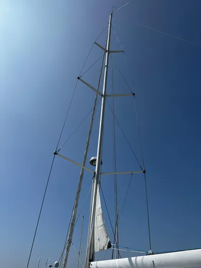 2.0 Impulsive Yacht Photos Pics Tall mast of a 2005 Beneteau 57 sailboat against a clear blue sky.