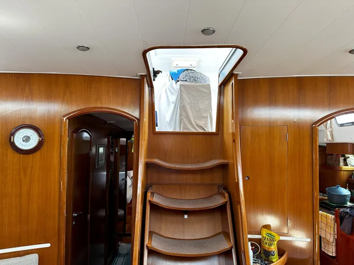 2.0 Impulsive Yacht Photos Pics Interior of 2005 Beneteau 57 yacht with wooden finish and staircase to deck.