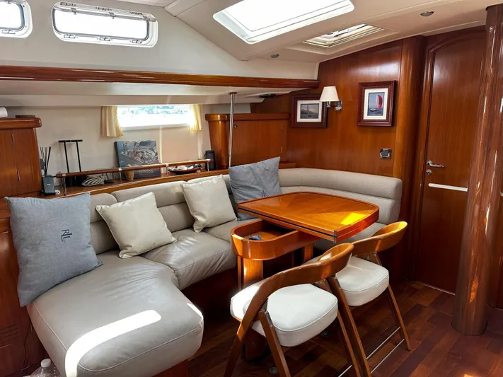 2.0 Impulsive Yacht Photos Pics Luxurious interior of 2005 Beneteau 57 yacht with elegant wood finish and comfortable seating.