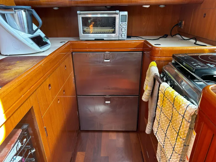 2.0 Impulsive Yacht Photos Pics Beneteau 57 yacht kitchen with modern appliances, wood cabinetry, and stainless steel drawers, 2005 model.