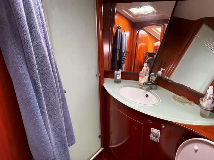 2.0 Impulsive Yacht Photos Pics Luxurious bathroom in 2005 Beneteau 57 yacht with modern fixtures and wooden cabinetry.