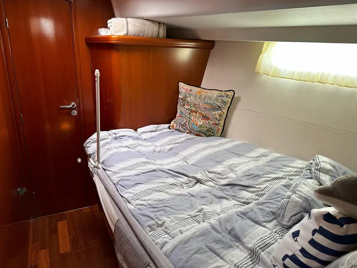 2.0 Impulsive Yacht Photos Pics Cozy cabin interior of 2005 Beneteau 57 yacht with wooden finish and comfortable bedding.