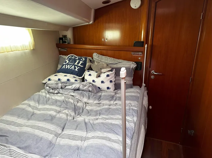 2.0 Impulsive Yacht Photos Pics Cozy cabin interior of 2005 Beneteau 57 yacht with nautical-themed bedding.