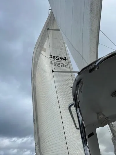 2.0 Impulsive Yacht Photos Pics Sailing yacht Beneteau 57, 2005 model, with sails unfurled against a cloudy sky.
